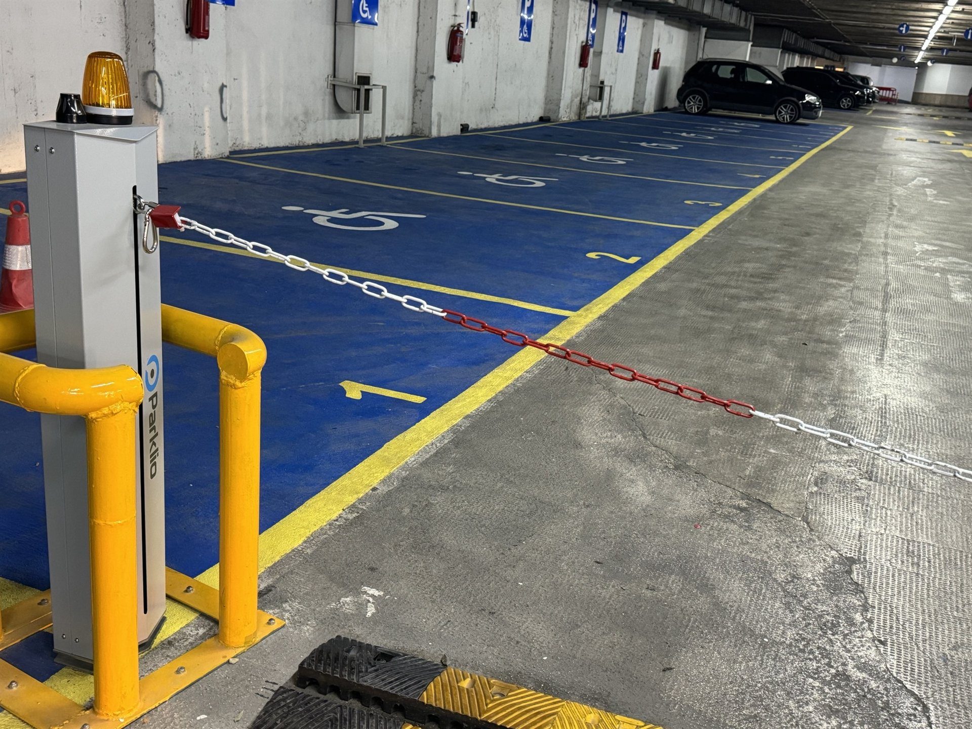 Kettenabsenker sichert markierte Behindertenparkplätze in einer Tiefgarage