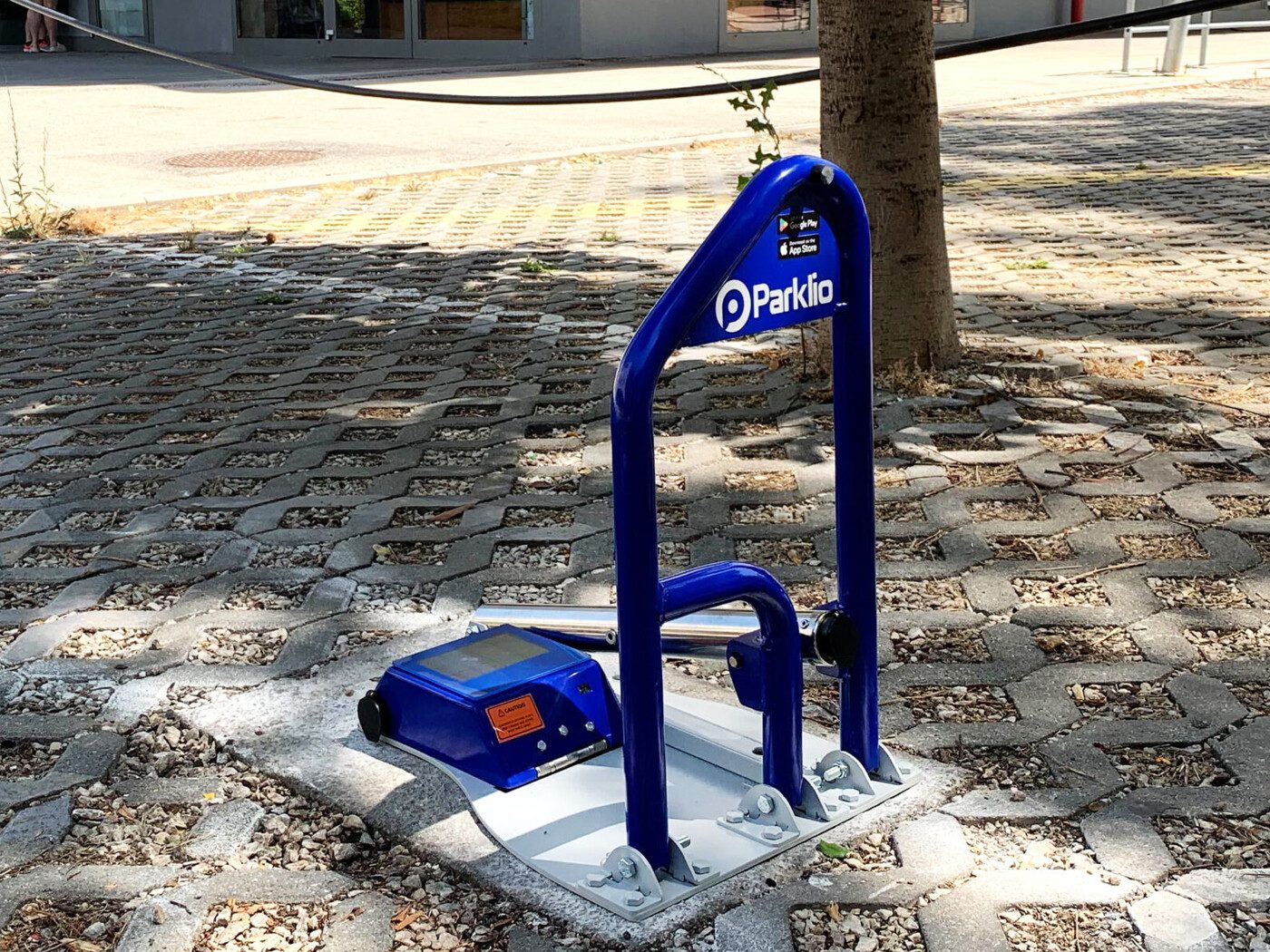 Installierter Parklio Parkbügel mit App-Store- und Google-Play-Hinweis am Bügel