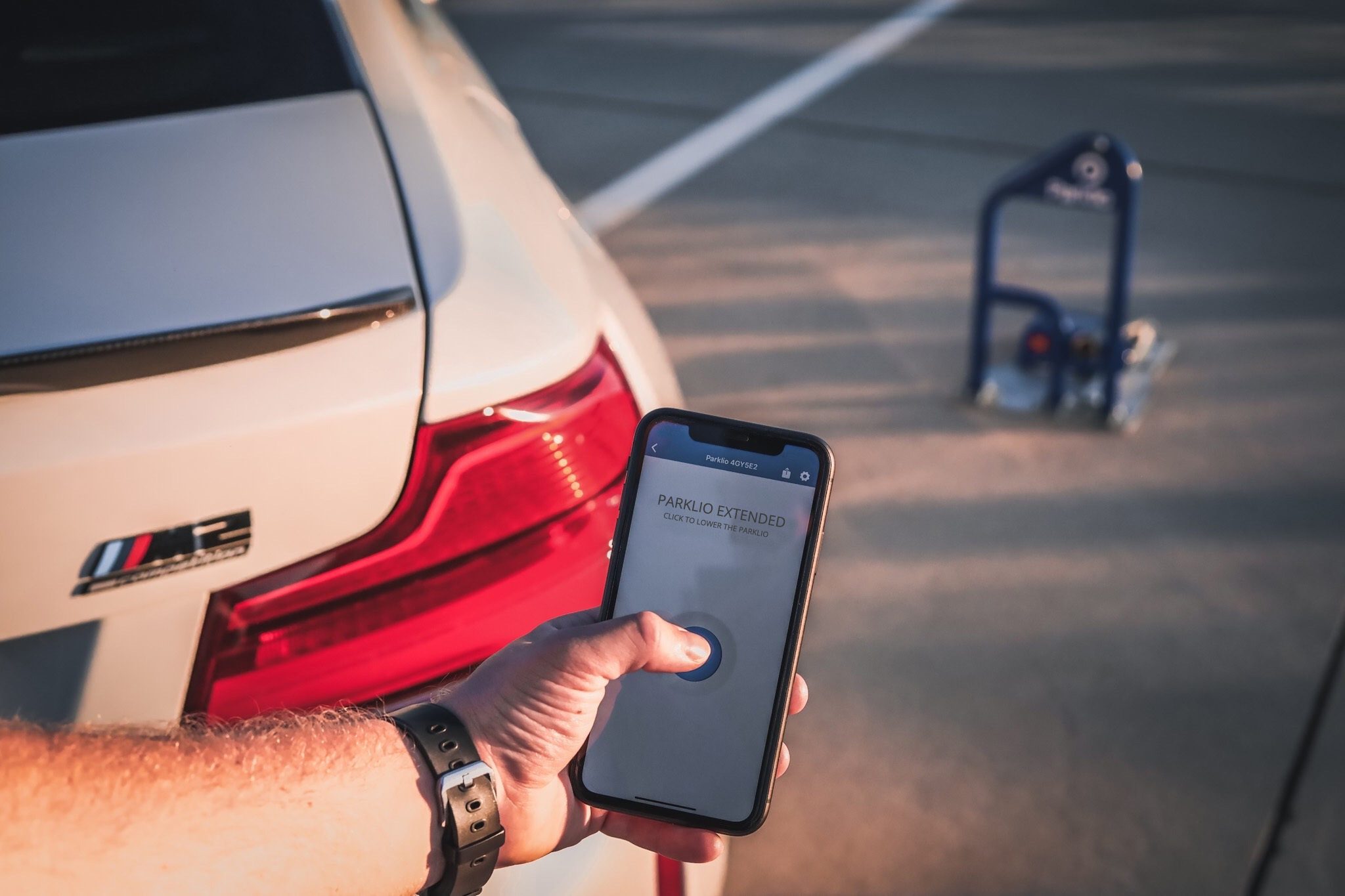 Parklio Connect App auf dem Smartphone senkt einen Parkbügel ab
