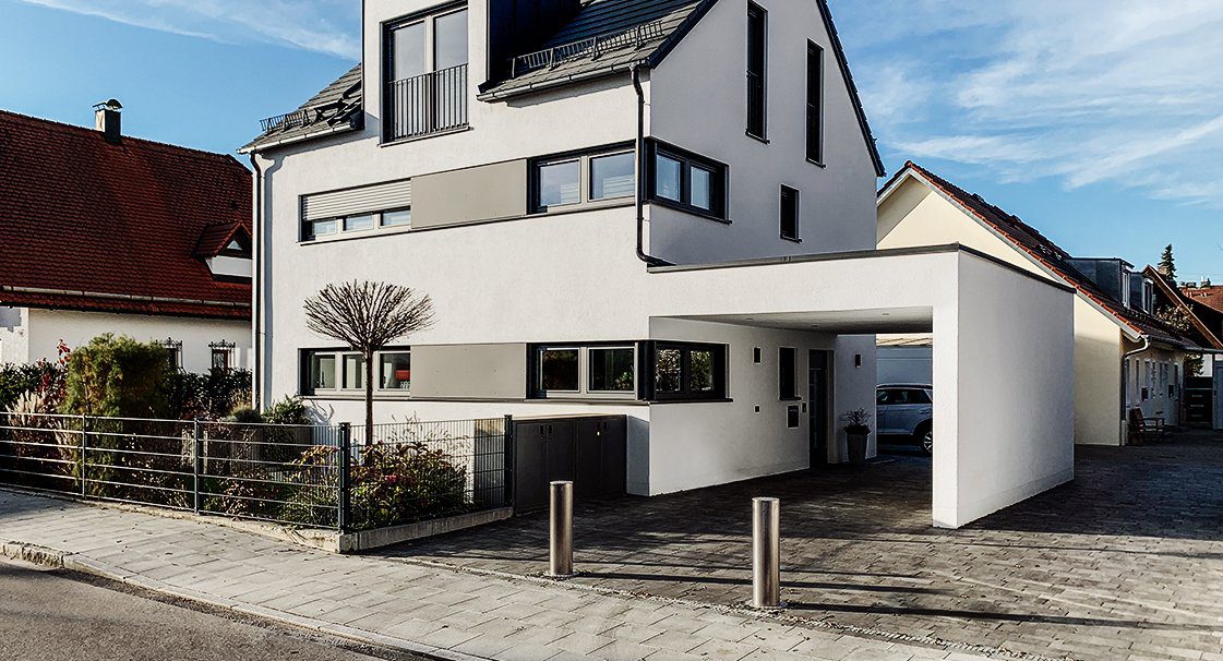 Zwei versenkbare Edelstahl-Poller sichern die Zufahrt eines Wohnhauses mit Carport